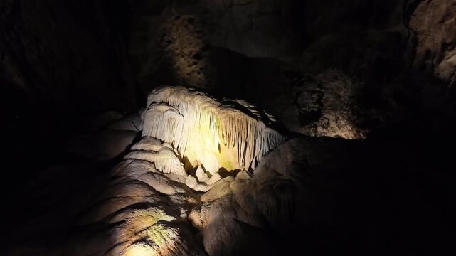 Illuminated stalactites and rock formations in a cave.