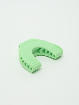 Light green silicone jawline exerciser and jaw trainer isolated on white background