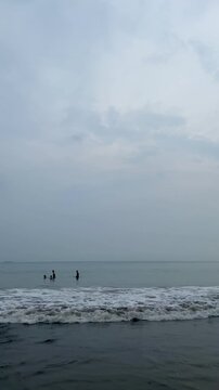 A small family is enjoying the gentle lapping of the waves off the coast
