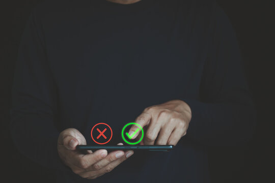 Businessman using a smartphone with green check and red cross icons, illustrating digital decision making, approval, rejection, verification, quality control, and online business evaluation.