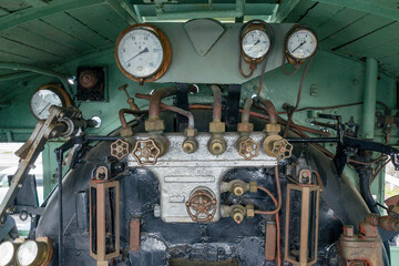 Vintage steam locomotive cabin interior with mechanical gauges, valves, and pipes © Shohei Kannauchi