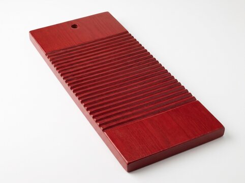 Red wooden washboard with corrugated ridged texture, isolated on white background, vintage hand laundry tool concept