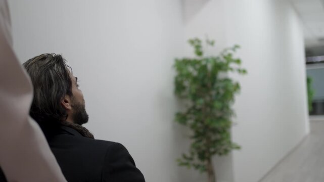 Coworker in wheelchair waves goodbye to colleagues in office