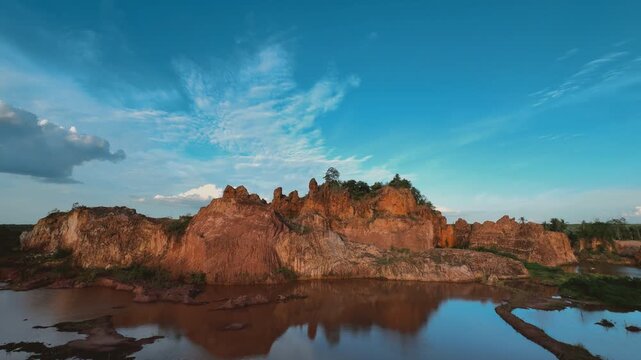 Dramatic Thai Landscape with Rugged Rock Formations Reflected in Calm Water Under a Blue Sky