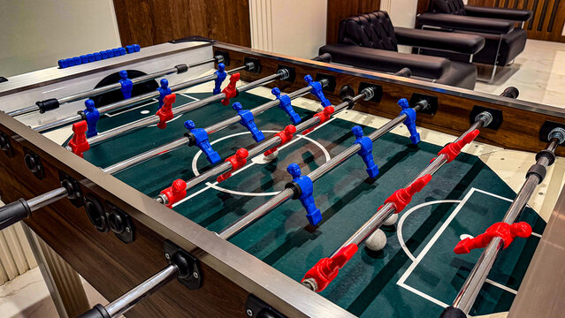 Table football game with red and blue players in a modern indoor recreation room, leisure, entertainment and competitive game concept.