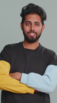 Indian handsome man shakes finger and saying No, be careful, scolding, giving advice to avoid danger mistake, disapproval sign. Young boy isolated alone on gray studio background. People lifestyle
