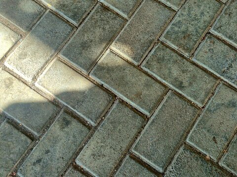 Herringbone pattern paving block floor texture with sunlight and shadow