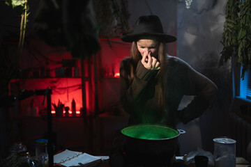 Realistic witch brewing a potion in cauldron disgusting cover nose bad smell. Blend of everyday life with traditional witchcraft, magic and mystical atmosphere © Andrii Lysenko