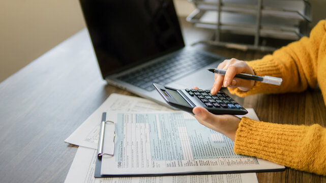 The concept of tax return preparation and financial management. Businessman calculates taxes. finance, Income tax, tax documents, and savings.