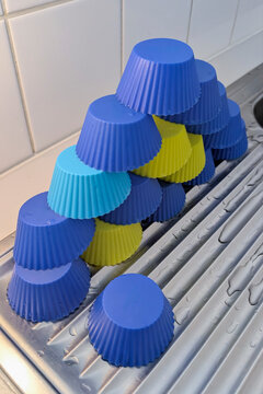 Stack of colorful silicone cups on a kitchen sink drying area