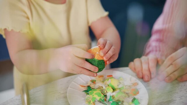 Child peels colorful candy with adult's help. Warm, focused moment. Joyful, patient, and educational. Perfect for holiday, family, or educational content. Safe, natural, and cheerful atmosphere
