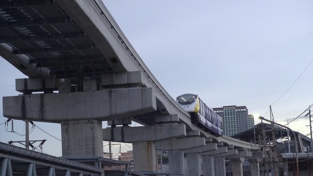 Bangkok, THAILAND - September 25, 2026 : The Yellow Line monorail is passing through the Bang Kapi intersection in Bangkok under dark, overcast skies that suggest rain is imminent.