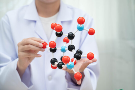 Scientist holding molecular model for chemical technology.