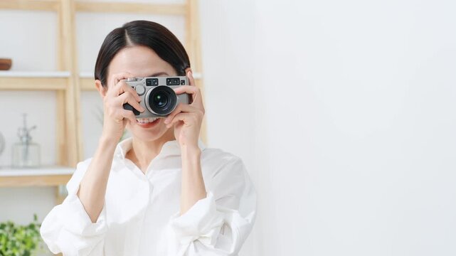 デジタルカメラを使う女性。写真、動画、編集、撮影、カメラマン、カメラ女子、現像、スタジオ、趣味、副業