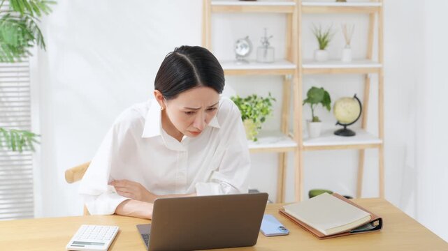 ノートPCを見ながらミドル女性。不安、心配、疑問、不満、動画、炎上、失敗、がっかり、落ち込む、疲労