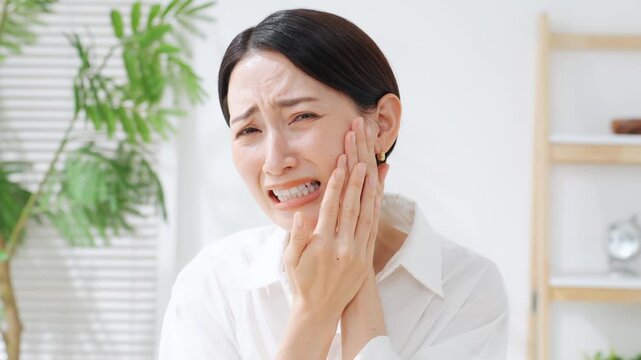 奥歯が痛むミドル女性。虫歯、親知らず、デンタルケア、歯科医、痛い、ストレス、困る、悩み、治療、歯医者