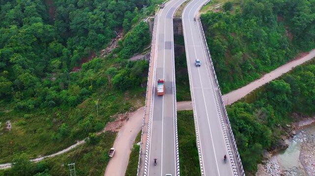 Top down Drone tracking shot of a Indian Cargo truck driving on highway bridge