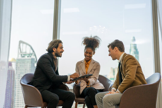 Business colleagues laughing over tablet during informal meeting