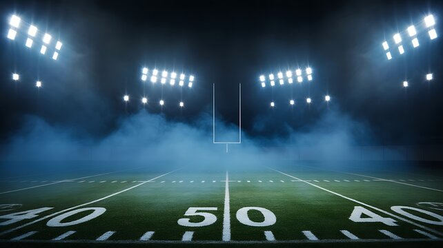 Empty football field under bright stadium lights at night