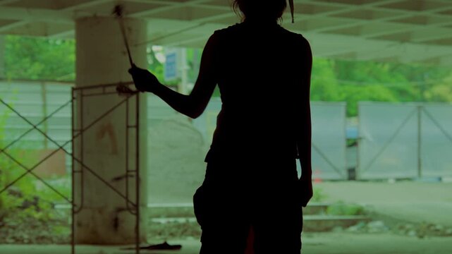 A badass female survivor stands in silhouette in a ruined building, confidently twirling a makeshift weapon. Post-apocalyptic or action movie concept.