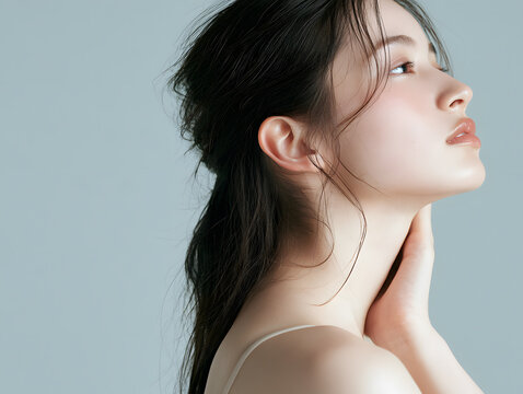 首元に手を添えて上を見つめる日本人女性の横顔