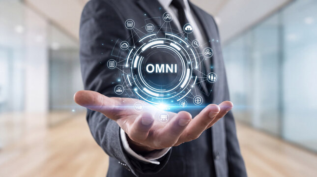 Businessman Holding Virtual Interface with OMNI Word and Digital Icons Representing Omnichannel Marketing Strategy, Business Connectivity, and Integrated Communication Technology Solutions