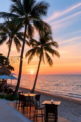 Fototapeta premium Tropical beach restaurant preparing for evening dining at sunset