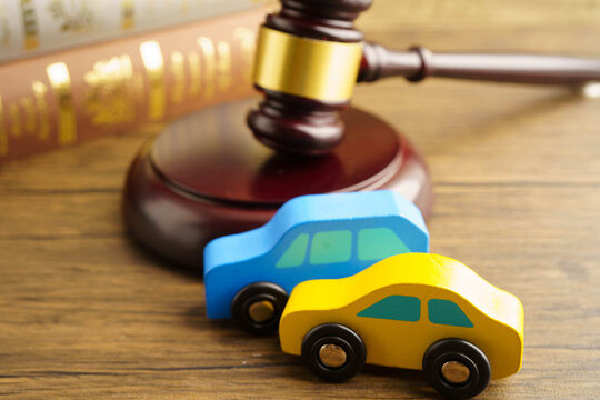 Car accident lawsuit and insurance, Judge hammer with car model.