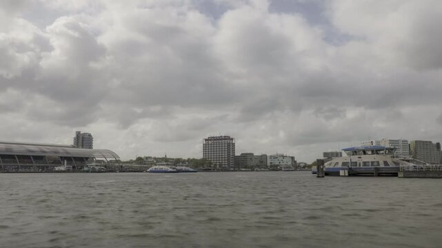 Free city ferries transporting people over the IJ in the city of Amsterdam. Central station on the left. Other water traffic consists of inland vessels, tourist cruise ships, and recreational craft.