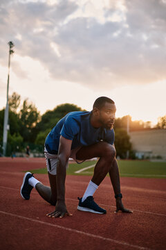 Male athlete in starting position on running track