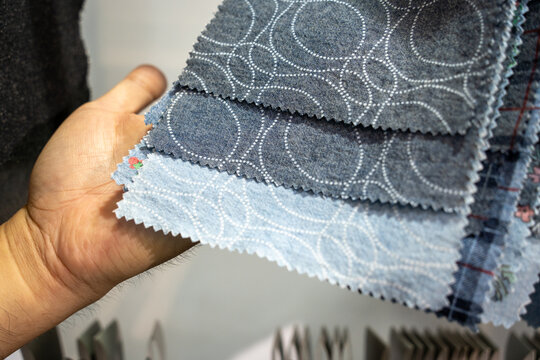 Multiple fabric samples with circular patterns held in a hand