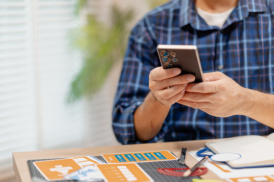 Designer working with color palettes, layout templates, and creative design tools on a desk while planning branding and graphic design projects in a modern office.