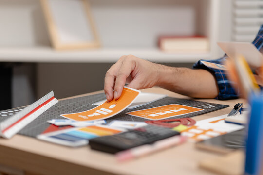 Designer arranging color swatches, layout samples, and branding materials on a creative workspace while planning a visual identity project with notebooks and design tools.