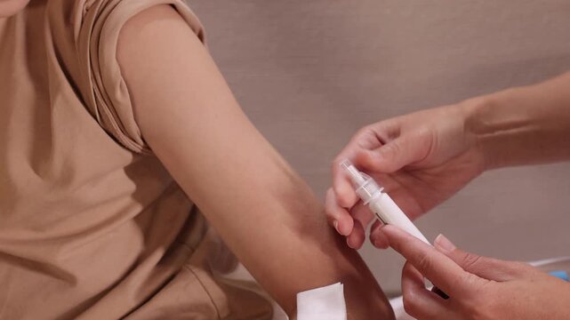 Adult prepares childs upper arm for an injection