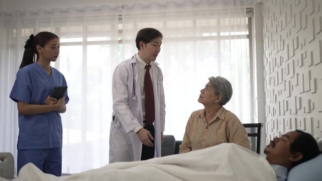 Hospital doctor explaining diagnosis to senior woman by patient bed