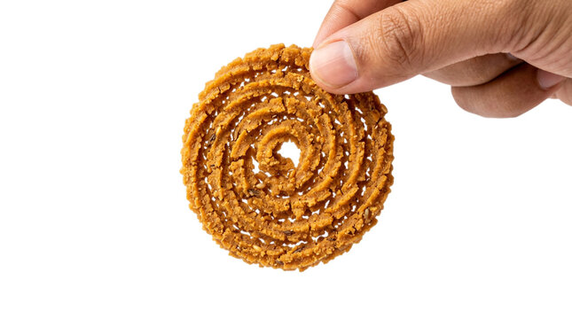 Hand holding crispy fried Indian chakli snack isolated on white