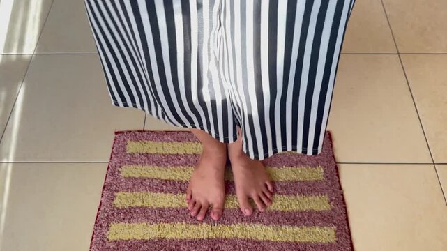 Video of cleaning feet with a foot scrubber tool inside a house.