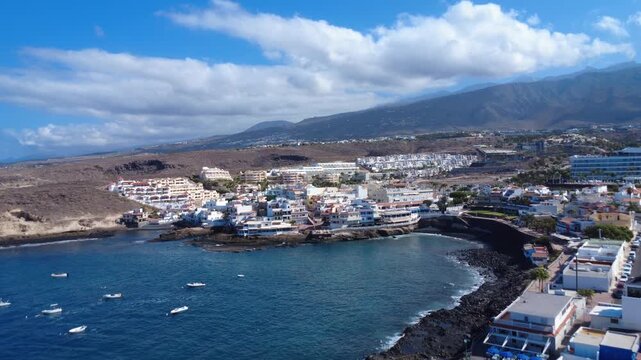 Vista a&eacute;rea de la bah&iacute;a de La Caleta con barcos fondeados, el pueblo y monta&ntilde;as bajo nubes blancas, Costa Adeje, Tenerife