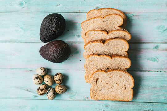 Ingredients for healthy breakfast toast with avocado and quail eggs