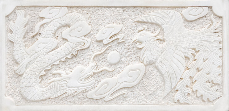 Traditional Chinese phoenix and dragon bas-relief sculpture on white stone wall