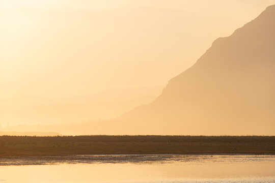 pastel sunset over placid lagoon and Klein Mountain reflection, Stanford, South Africa
