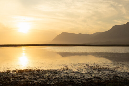 pastel sunset over placid lagoon and Klein Mountain reflection, Stanford, South Africa