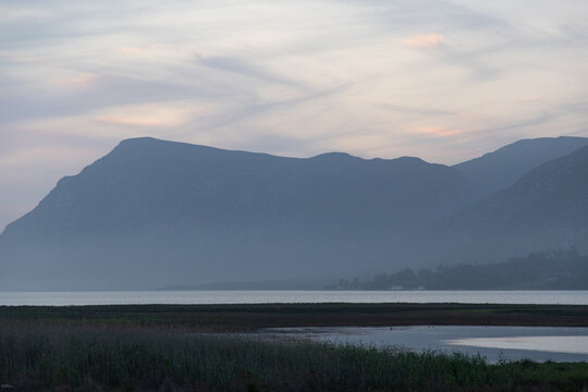 pastel sunset over placid lagoon and Klein Mountain reflection, Stanford, South Africa