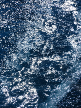 Deep blue sea behind a moving boat