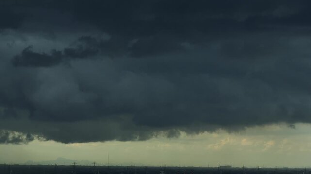 Dark towering cumulonimbus clouds spread across the horizon, highlighting powerful thunderstorms, unstable weather patterns, intense precipitation and the effects of a warming climate. 4k.
