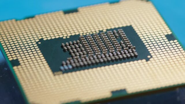 CPU computer microprocessor chip showing golden pins and capacitors on a blue background as a conceptual backdrop for artificial intelligence hardware semiconductor innovation cloud computing and info