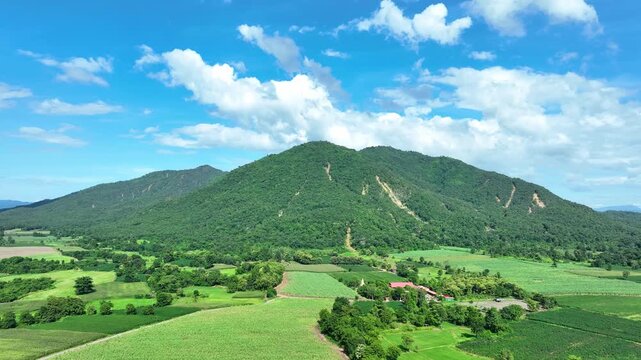 Aerial perspective shows exposed landslide scars across a densely forested mountain, illustrating erosion, slope failure, natural disaster risk and landscape degradation. Uttaradit Province, Thailand.