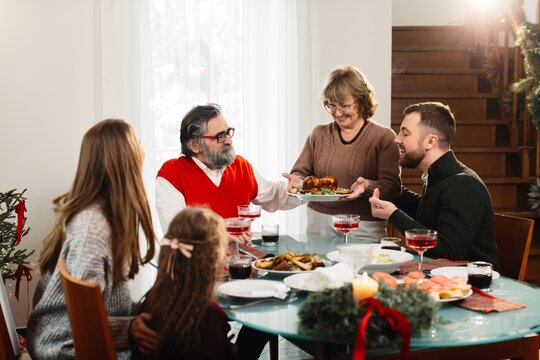 Family celebrating christmas dinner, sharing festive meal