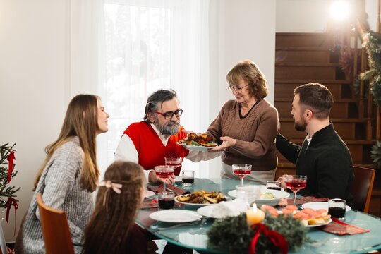 Family celebrating christmas dinner, sharing festive meal
