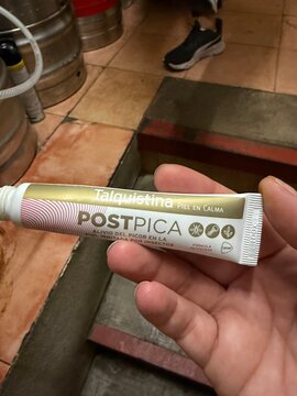 Mallorca, spain, septiembre 18, 2026 hand holding talquistina postpica tube, finding relief from insect bites, soothing irritated skin